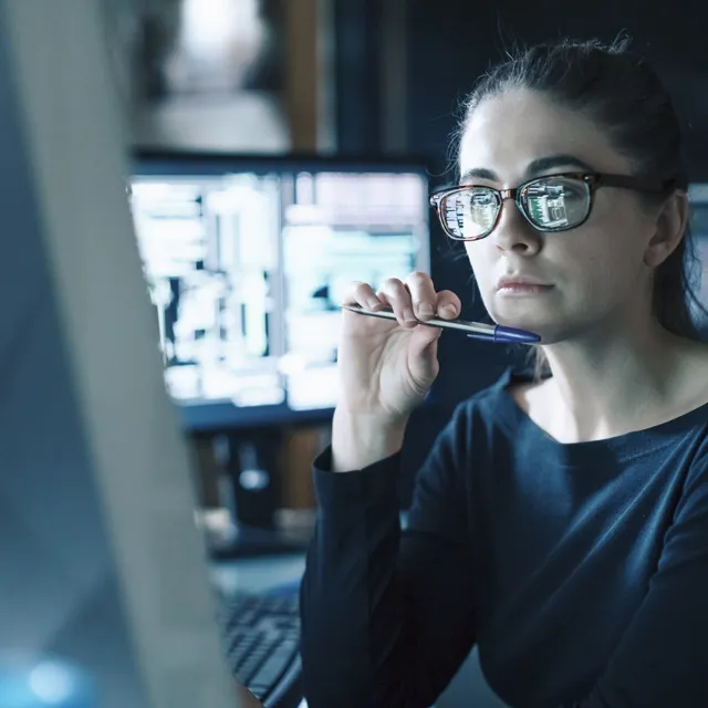 Woman looking focused while working on a computer screen
