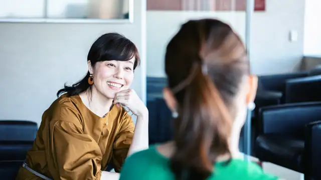 Happy women having a conversation in the office