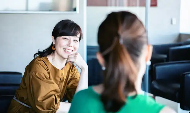 Happy women having a conversation in the office