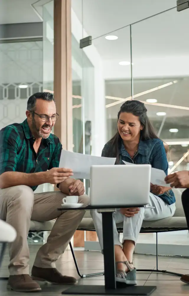 Group of happy people sitting down looking at a paper