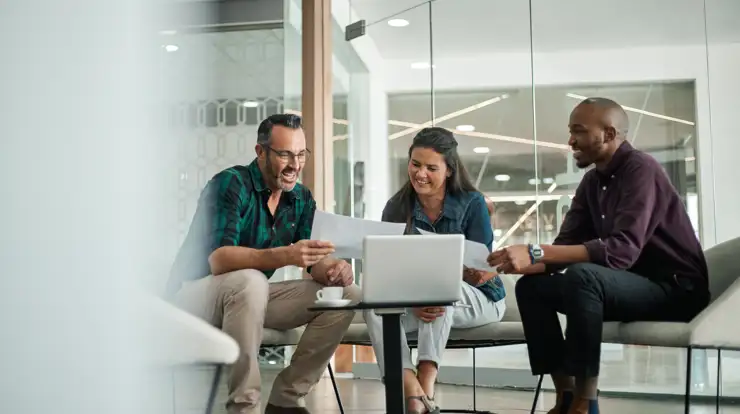 Group of happy people sitting down looking at a paper