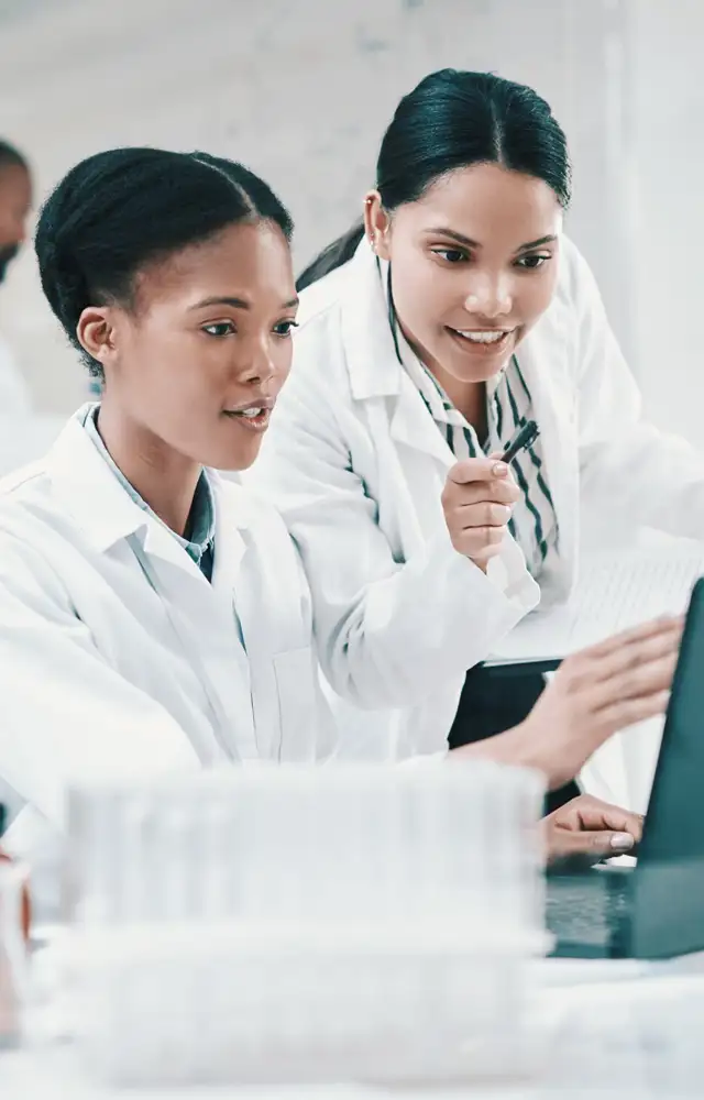Two laboratory employees looking at a screen