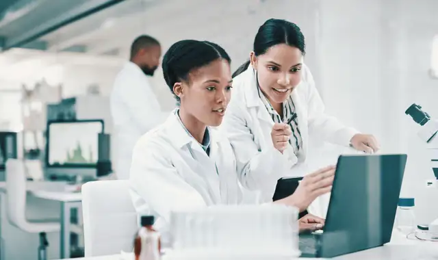 Two laboratory employees looking at a screen