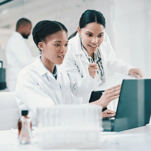 Two laboratory employees looking at a screen