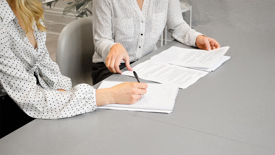 Two women discussing paperwork