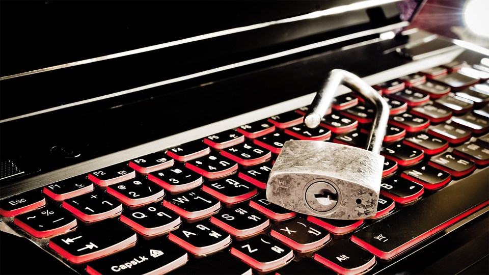 cybersecurity setup, metal lock on red lit keyboard