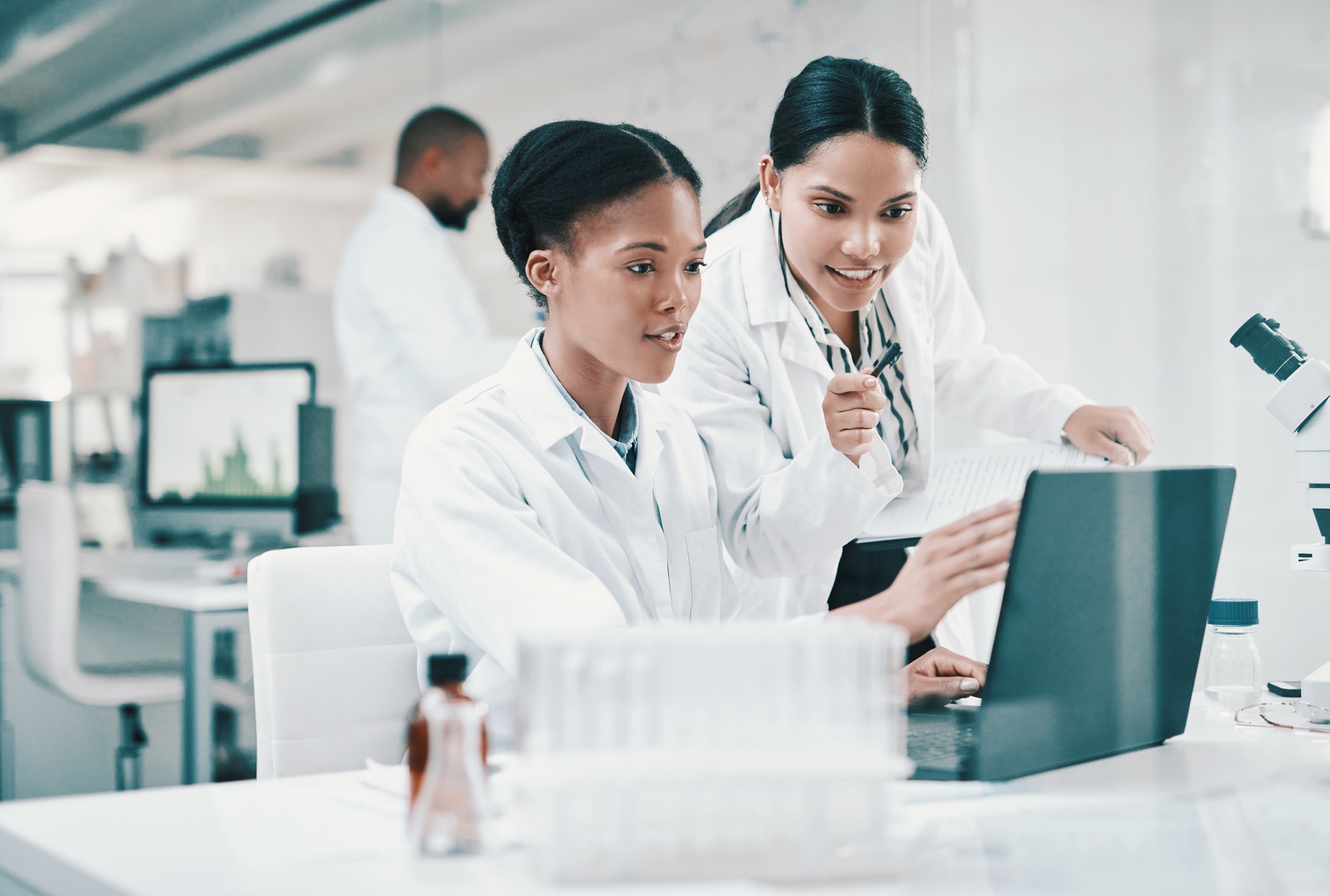 Life sciences professionals using digital tools in a laboratory to support compliant, data-driven operations and technology transformation.