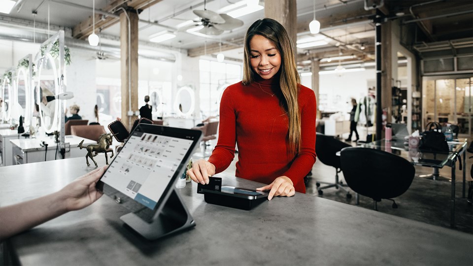 Woman using credit card at register