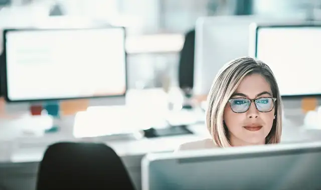 Woman sitting at her desk looking at screen