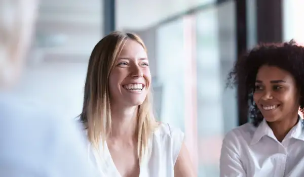 Woman with coffee laughing sitting in business environment