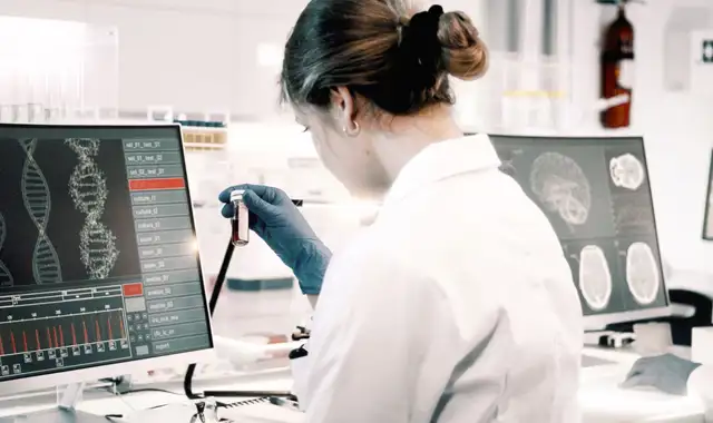 Two laboratory employees working on something in a lab