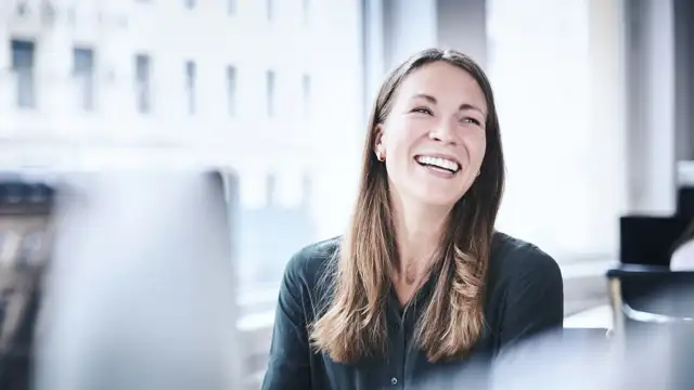 Happy woman at her work station in the office