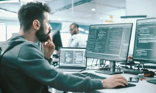 Man sitting in a office environment coding