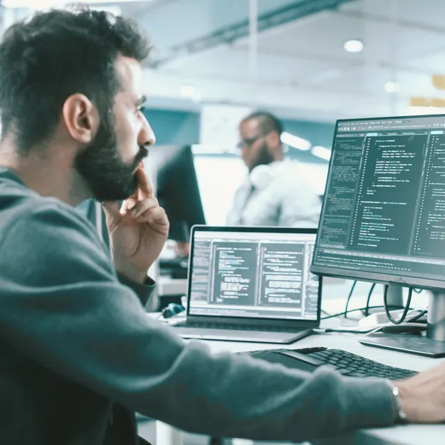 Man sitting in a office environment coding