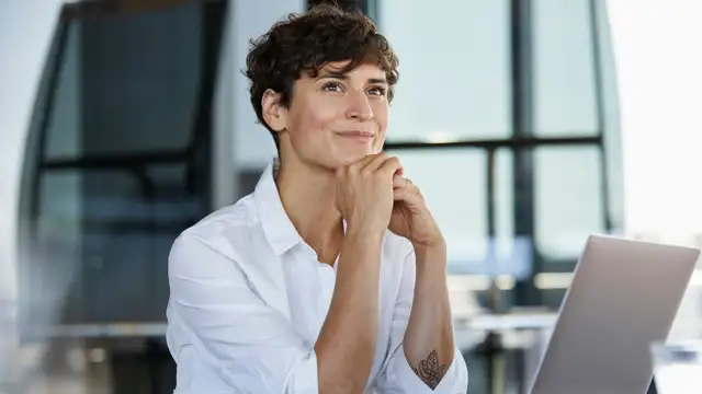 Woman setting a at desk looking interested