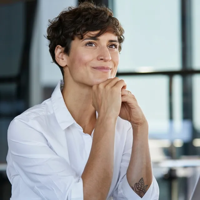 Woman setting a at desk looking interested